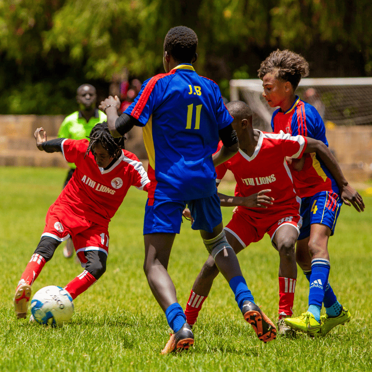 young boy footballers struggling to win the ball