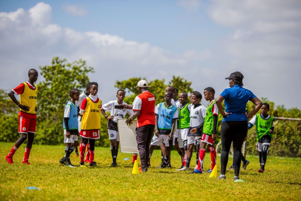 young boys at a football field with their coaches